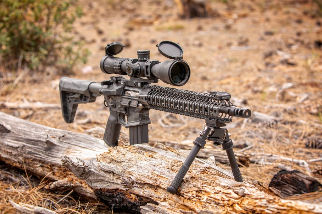 AR 15 rifle with a Primary Arms scope attached set out in the woods