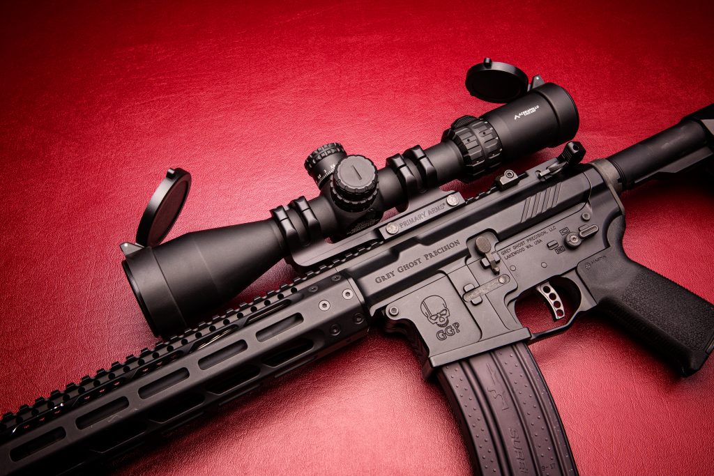 semi automatic AR15 rifle with scope on red background