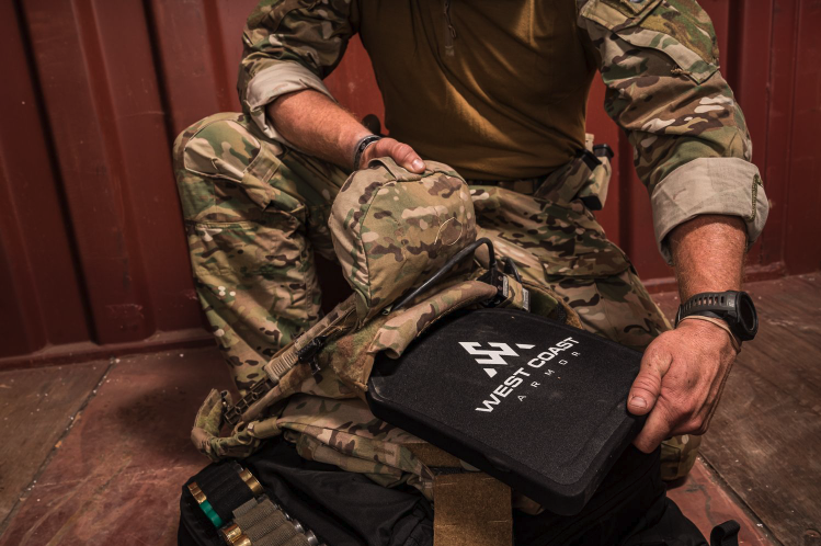 Person pulling West Coast Armor from a vest