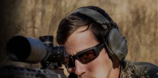 Man aiming a rifle and wearing Revision's glasses