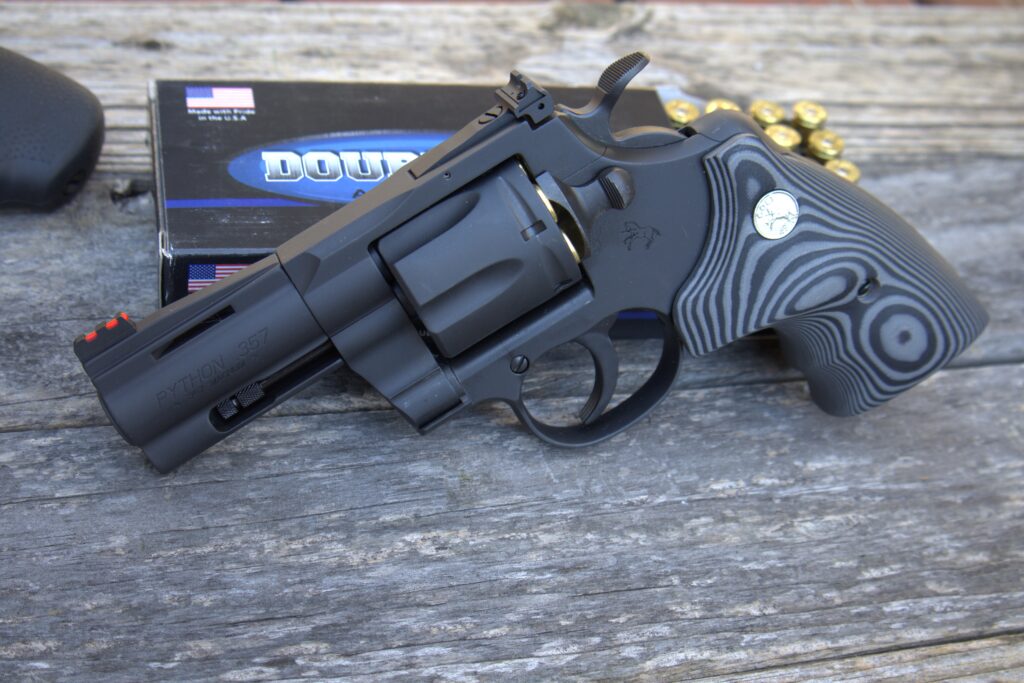 colt matte blue python with a box of ammunition